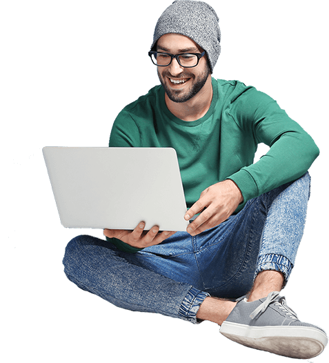 A man is working on his laptop with a smile